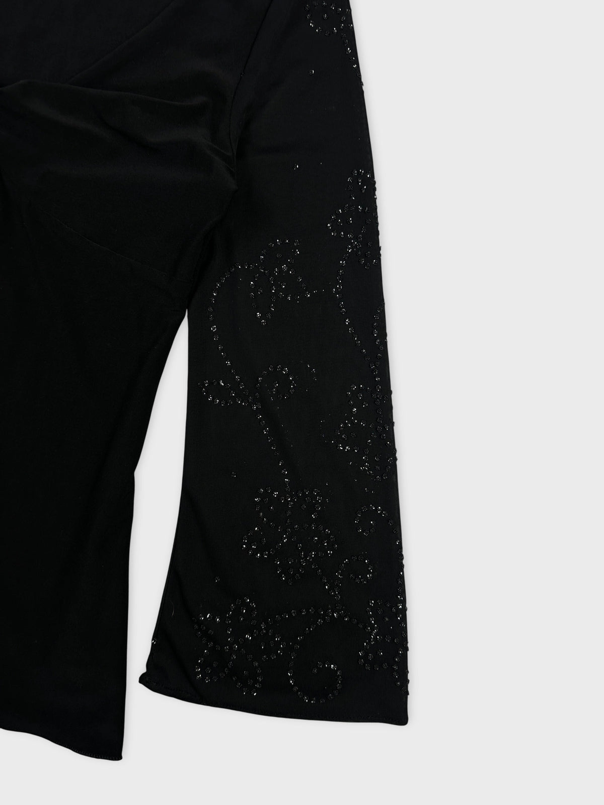 Detail view of a black women body shirt with floral rhinestone pattern.