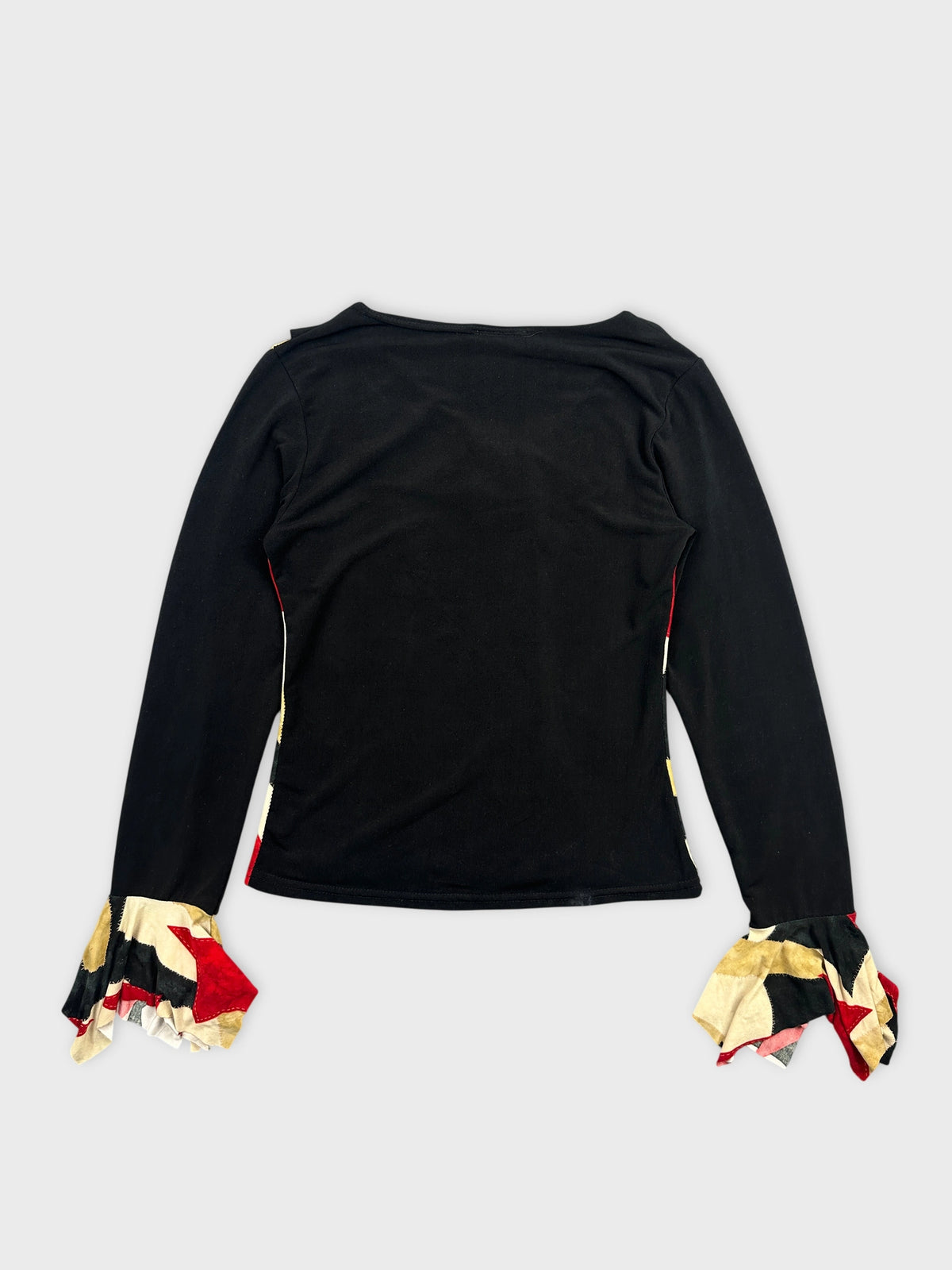 Back view of a black body shirt with colorful ruffled sleeves.