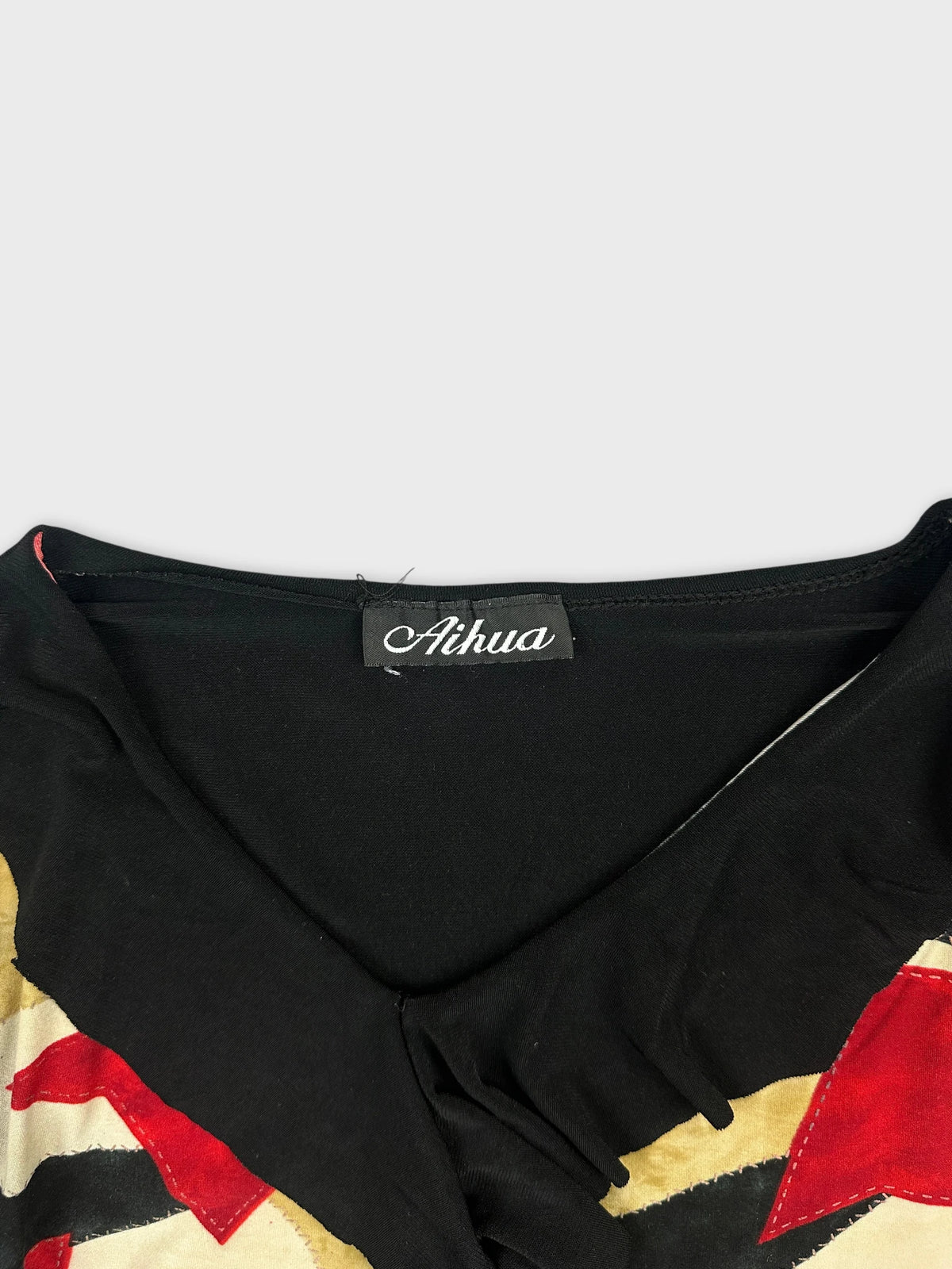 Detail view of a vintage black body shirt with colorful print.