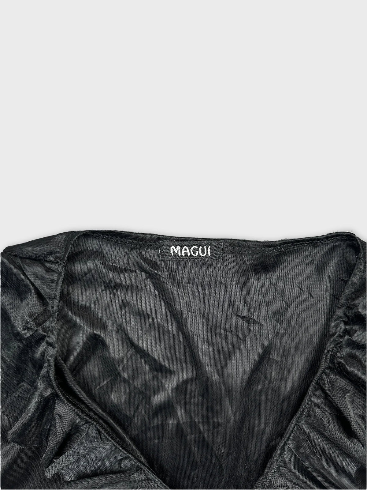 Detail view of a black body shirt showing the neckline and label.