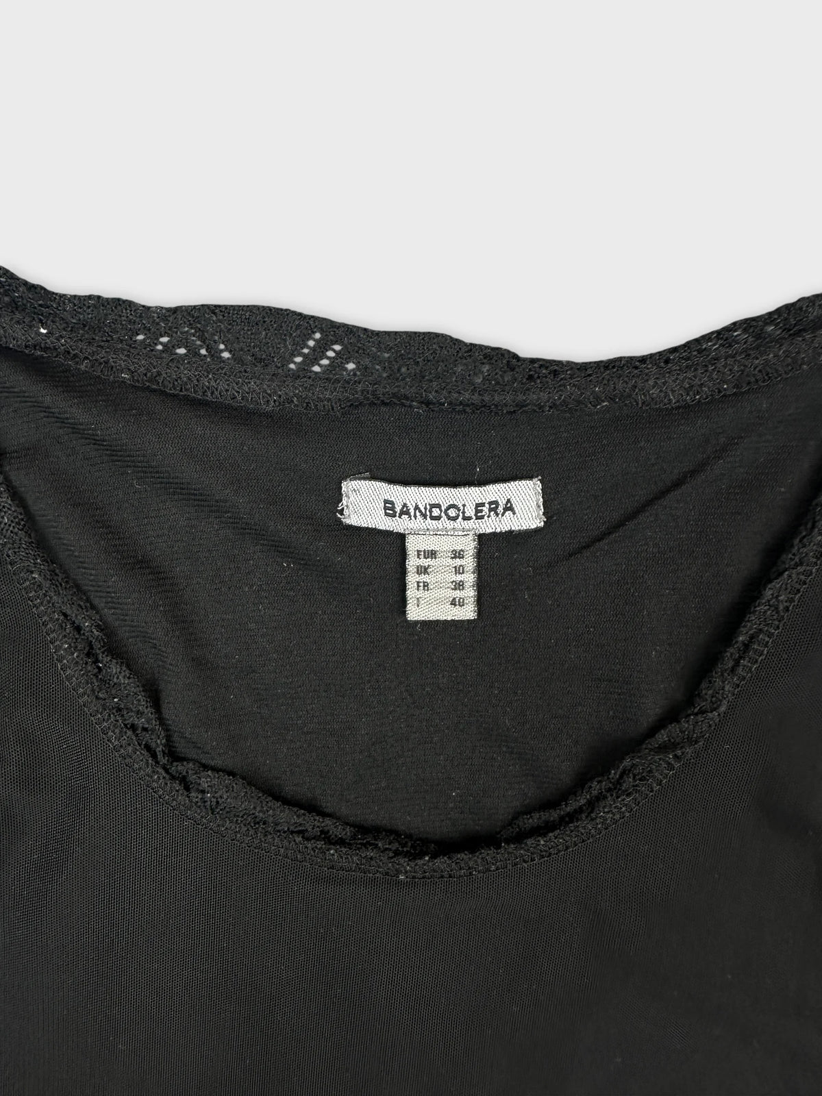 Detail view of a black women body shirt with lace trim.