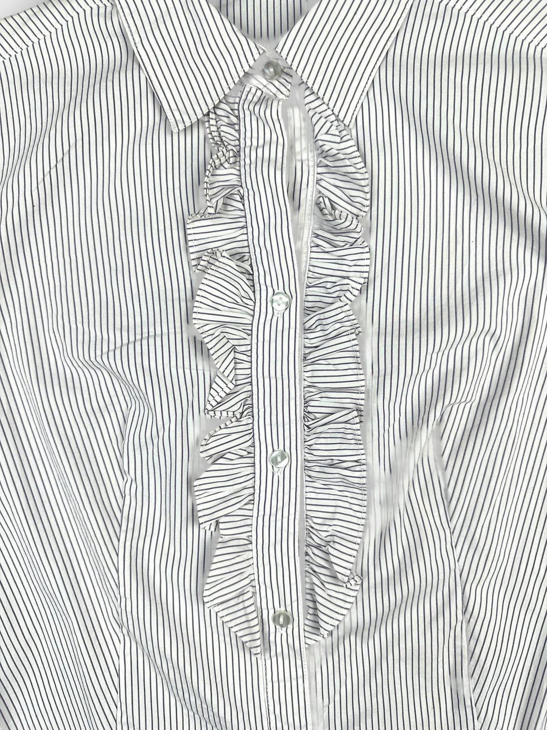 Detail view of a striped ruffled bodysuit in white and navy.