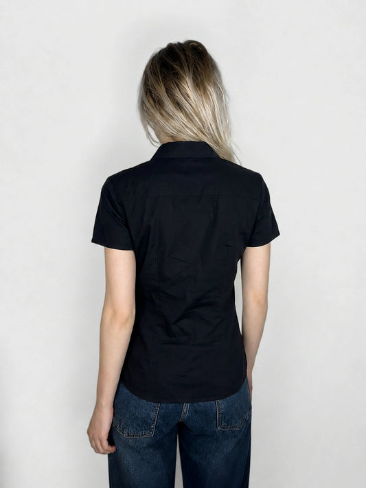 Back view of a black women’s body shirt with a collar.
