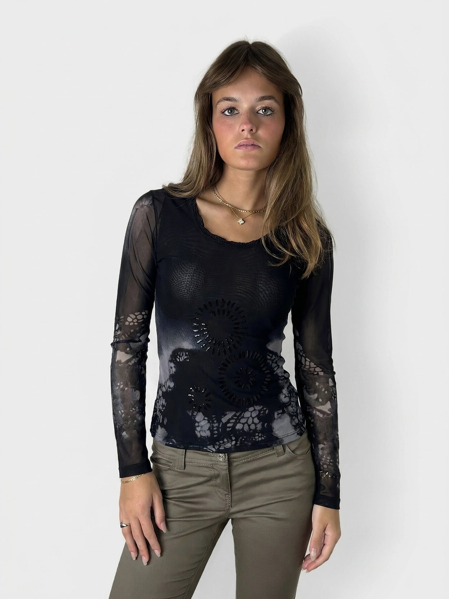Front view of a black body shirt featuring a floral lace pattern.