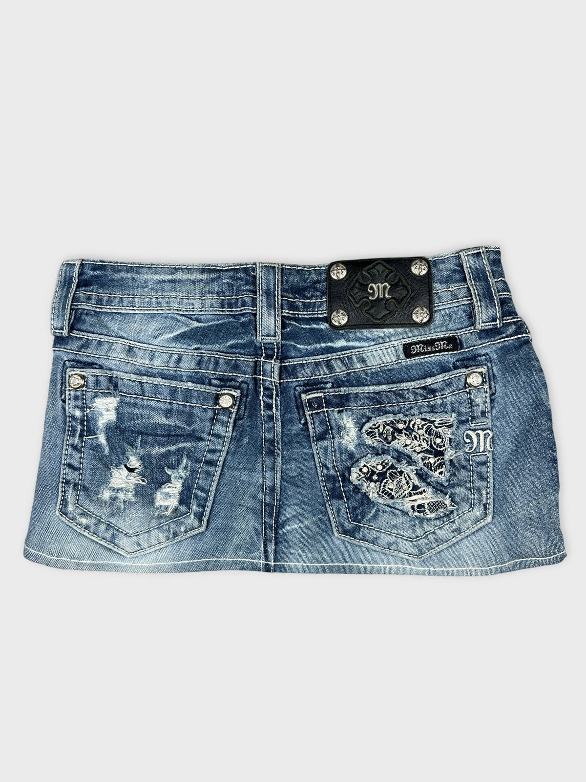 Back view of blue denim body shorts with embroidered pockets.