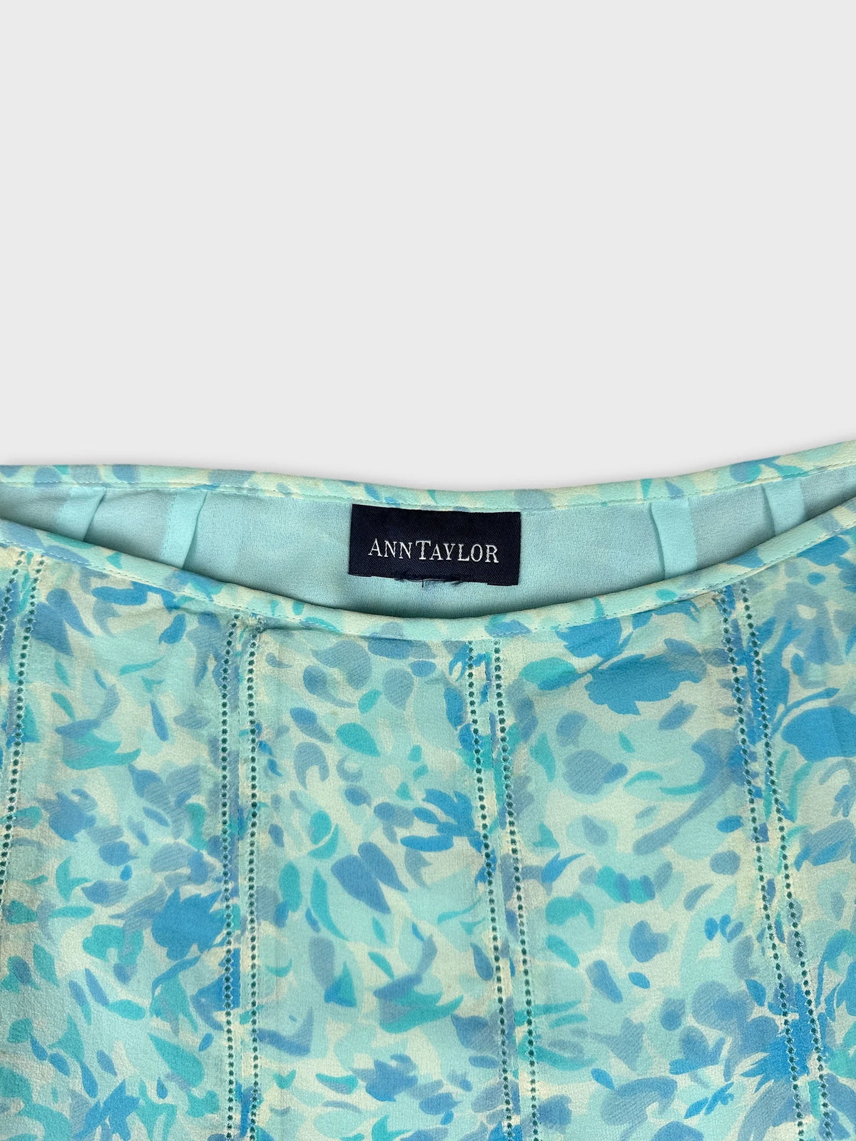 Detail view of a mint green floral print dress with delicate stitching.