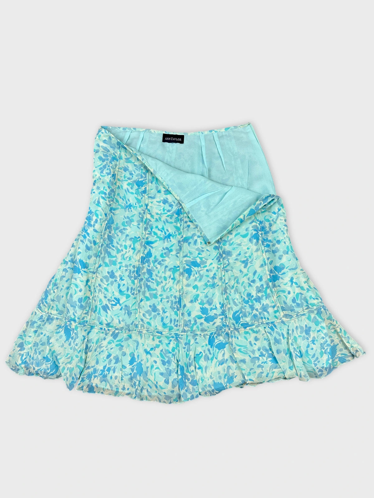 Detail view of a blue floral print skirt with a ruffled hem.