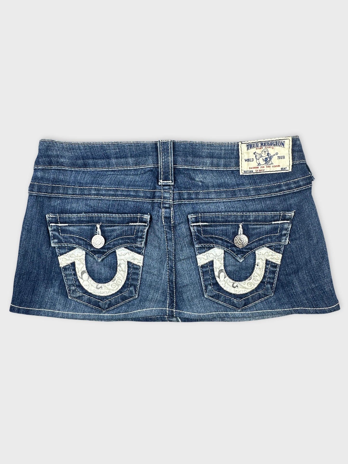 Detail view of a blue denim skirt with decorative back pockets.