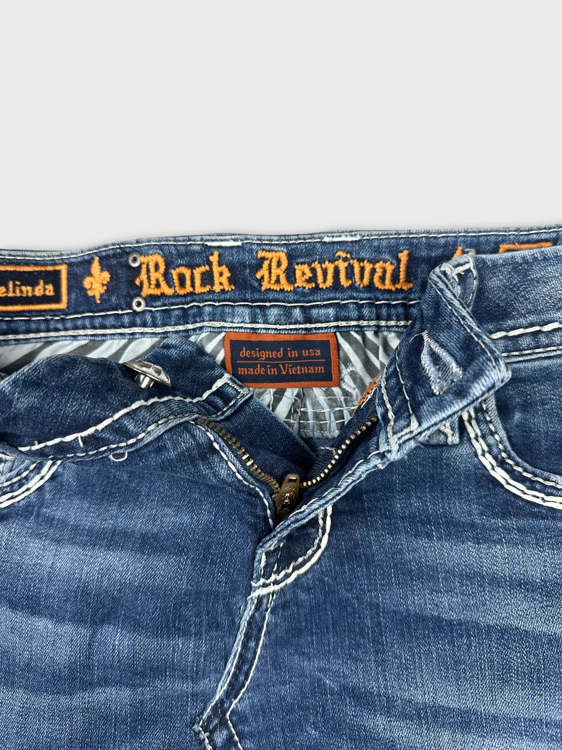 Detail view of denim mini skirt showing blue color and zip closure.