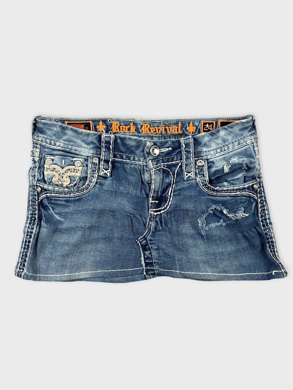 Front view of a denim mini skirt in blue with distressed details.