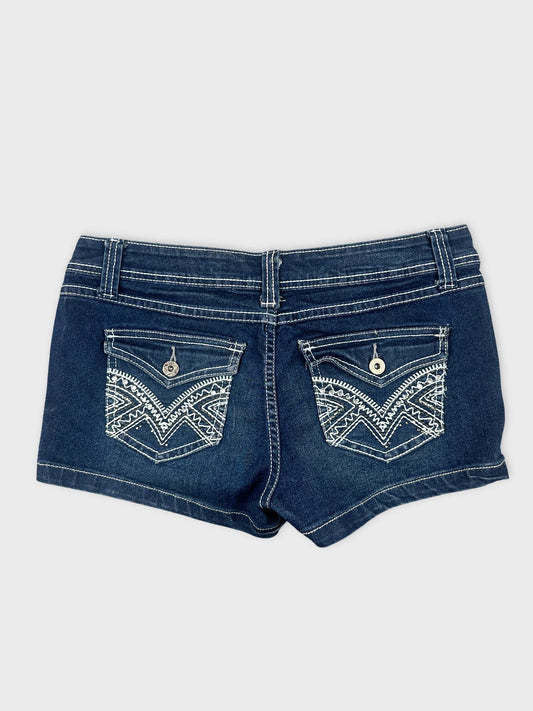 Back view of denim shorts in dark blue with embroidered pockets.