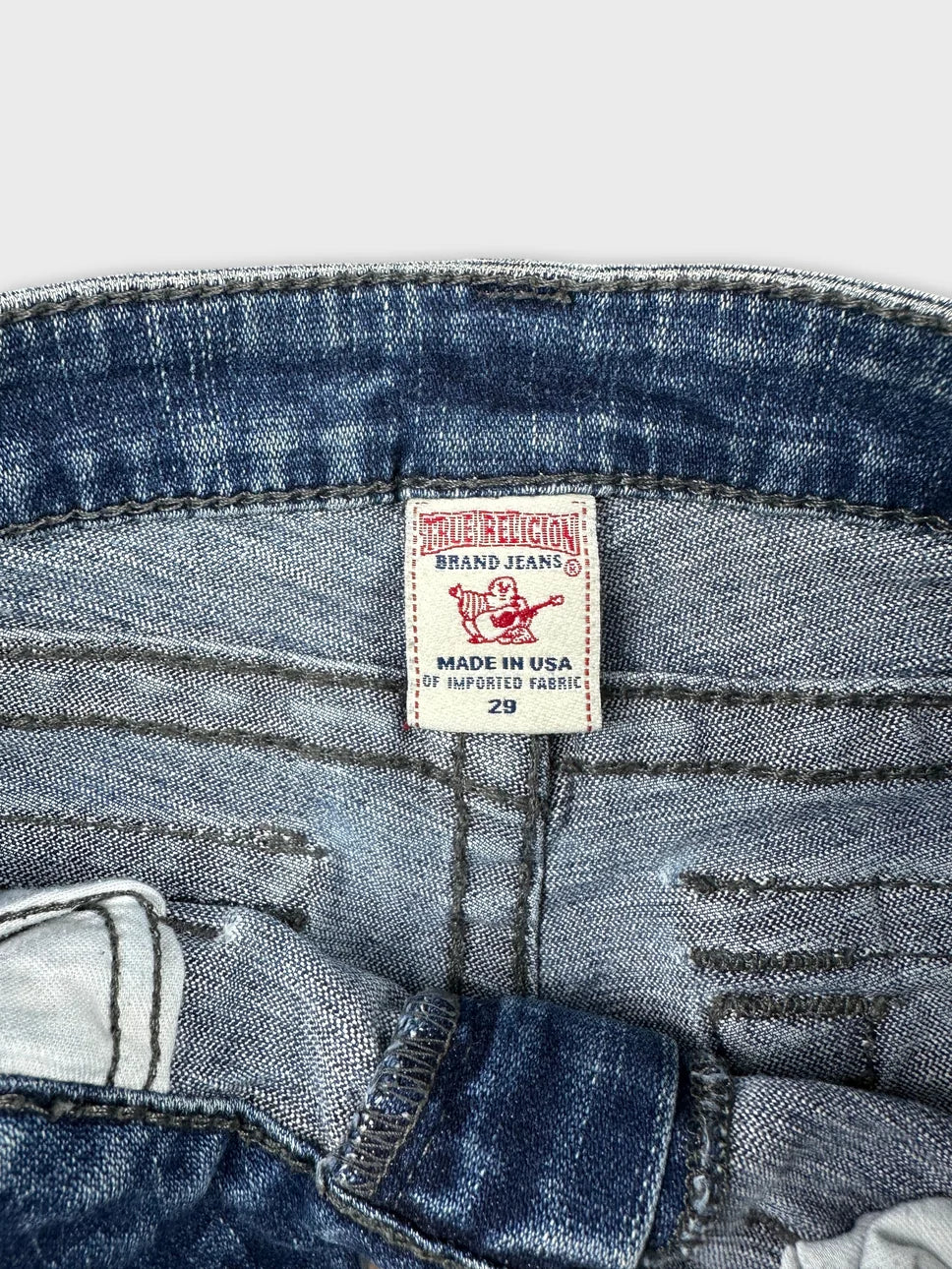 Denim shorts detail view featuring a blue wash and label stitching.