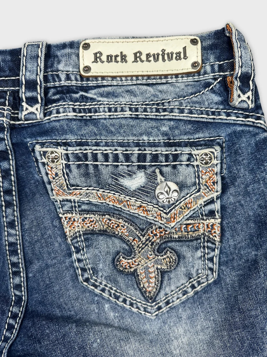 Detail view of blue denim shorts featuring embroidered back pocket design.