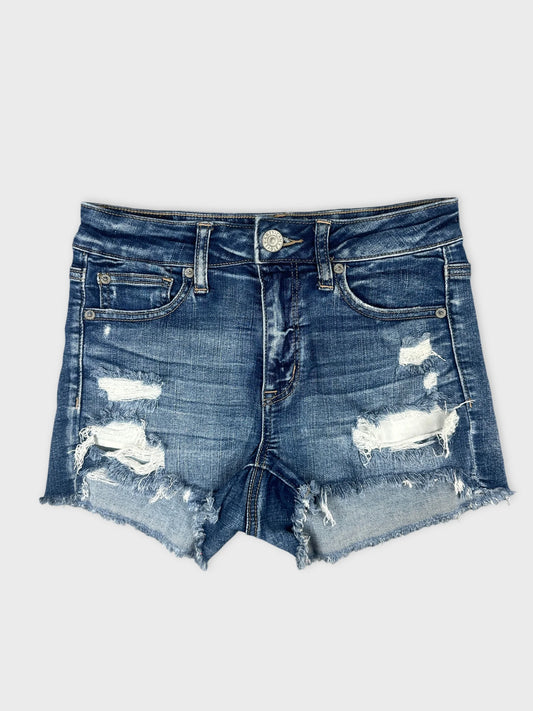 Front view of denim shorts in dark blue with distressed hem details.