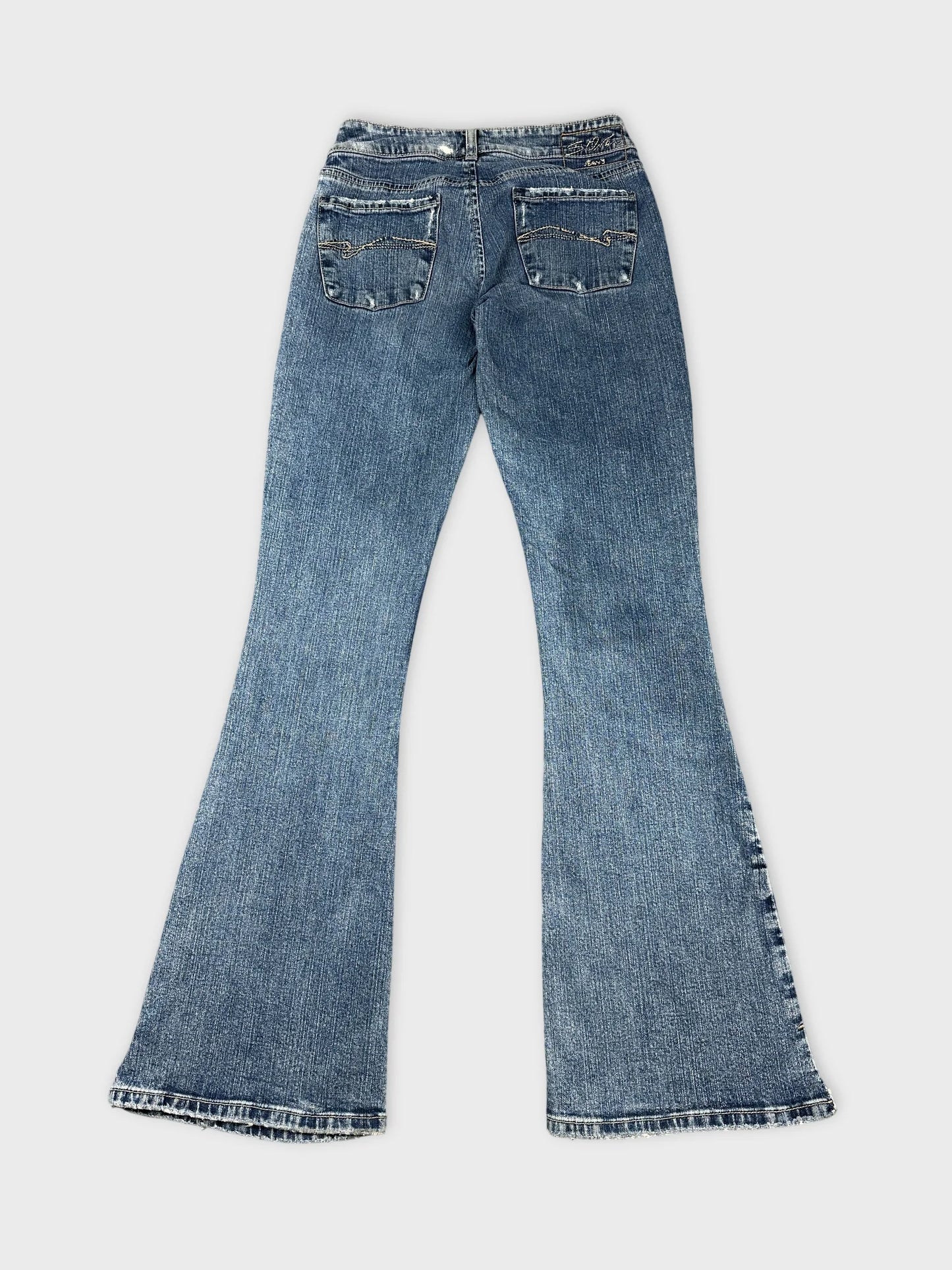 Back view of flared blue jeans with detailed stitching on pockets.