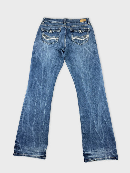 Back view of long blue jeans featuring embellished back pockets.
