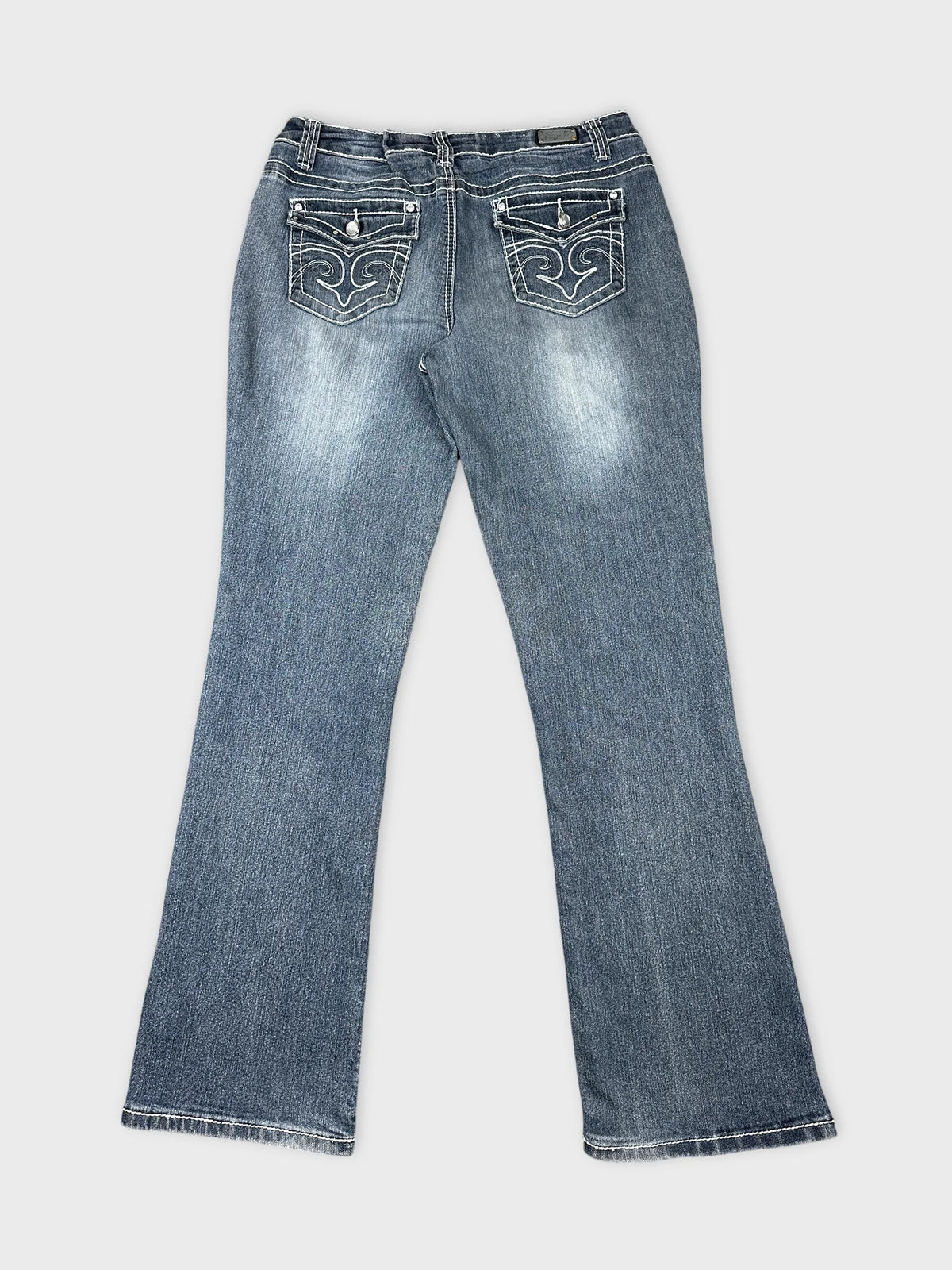 Back view of women long jeans in dark blue with decorative stitching on pockets.