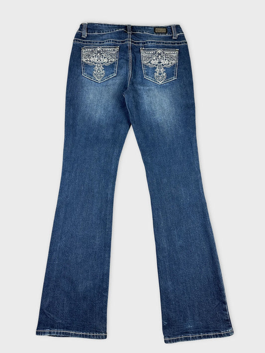Back view of blue jeans featuring decorative embroidery on pockets.