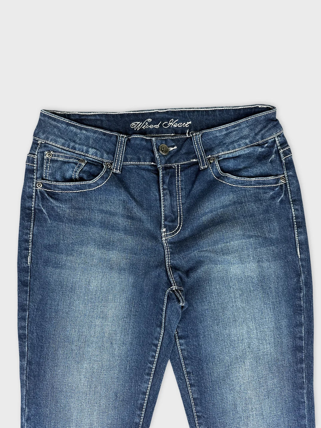Detail view of dark blue long jeans showcasing a classic fit and stitching.