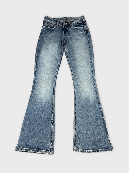 Front view of blue flared jeans with frayed hems.