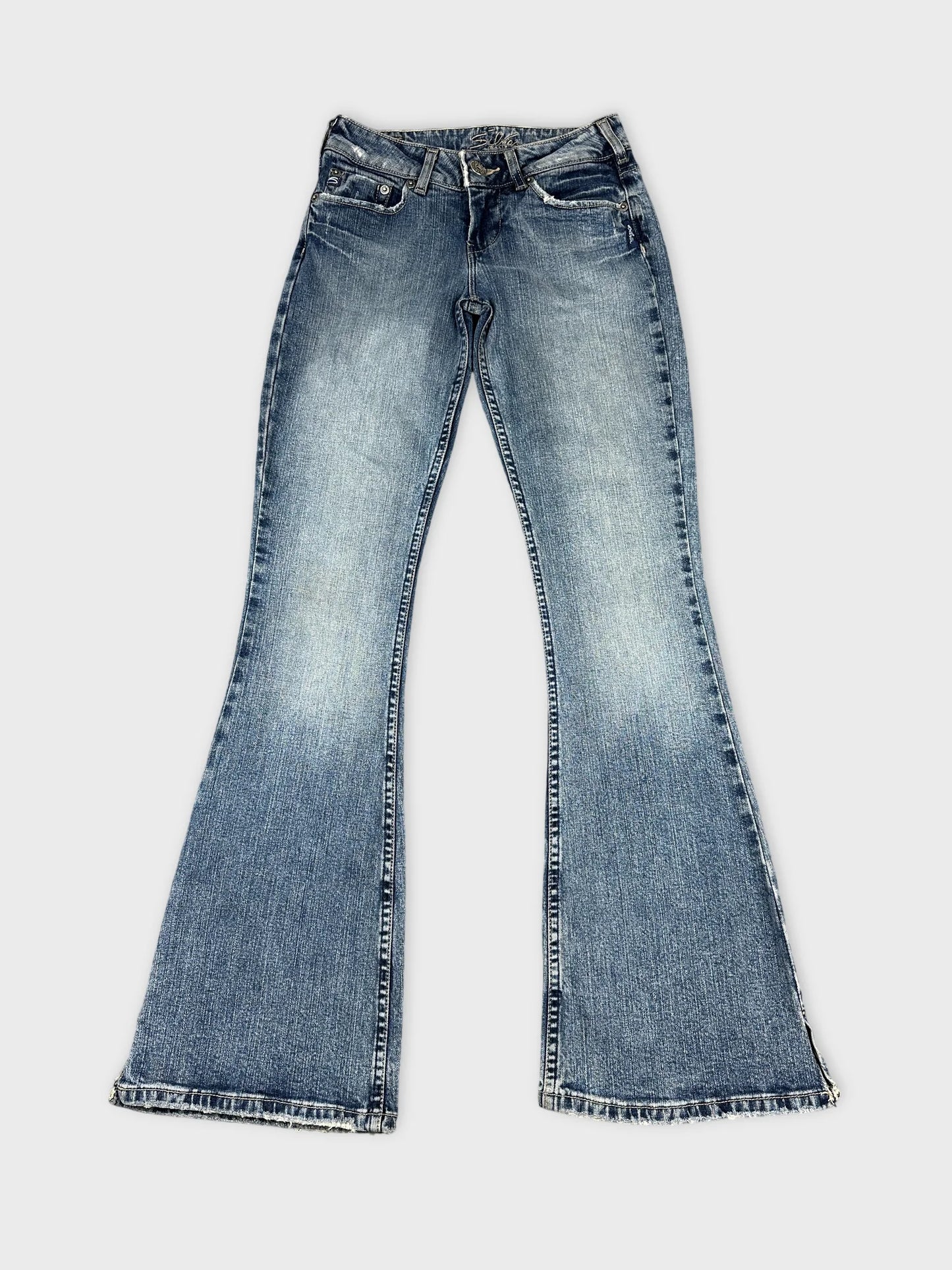 Front view of blue flared jeans with frayed hems.