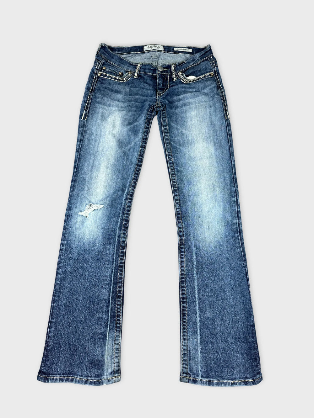 Front view of long blue jeans featuring a distressed detail near the knee.