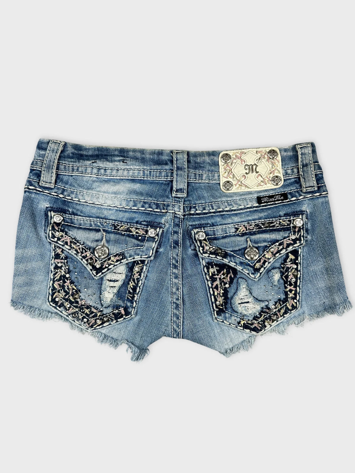 Back view of blue denim mini shorts with embroidered pockets.