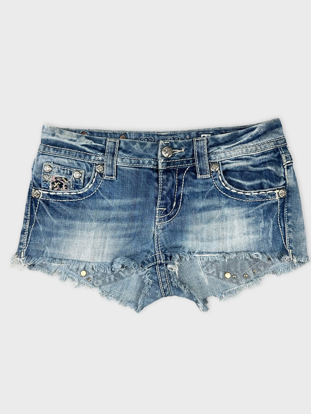 Front view of blue mini shorts featuring a frayed hem and decorative studs.