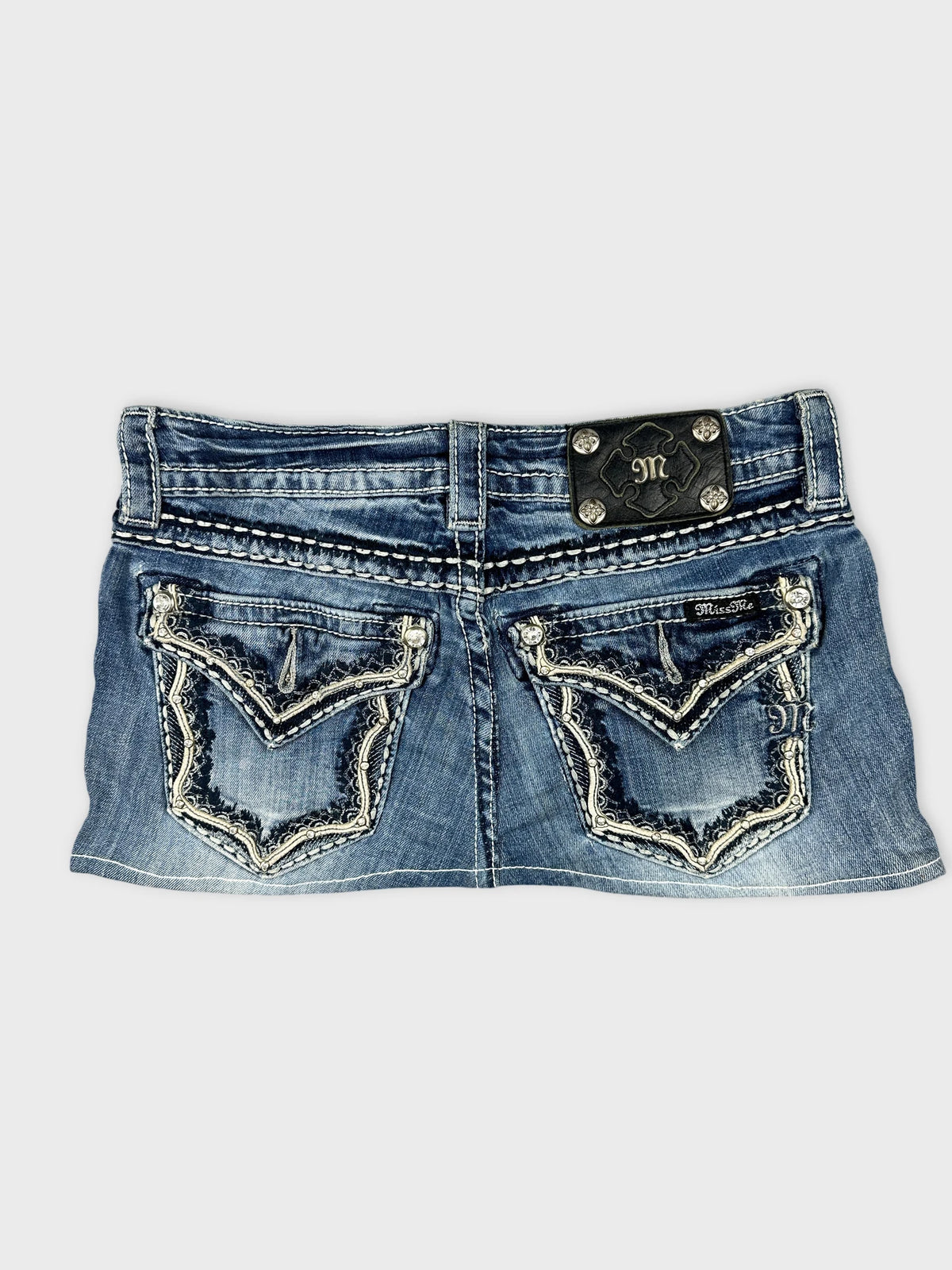 Back view of a blue mini skirt featuring embroidered pockets.