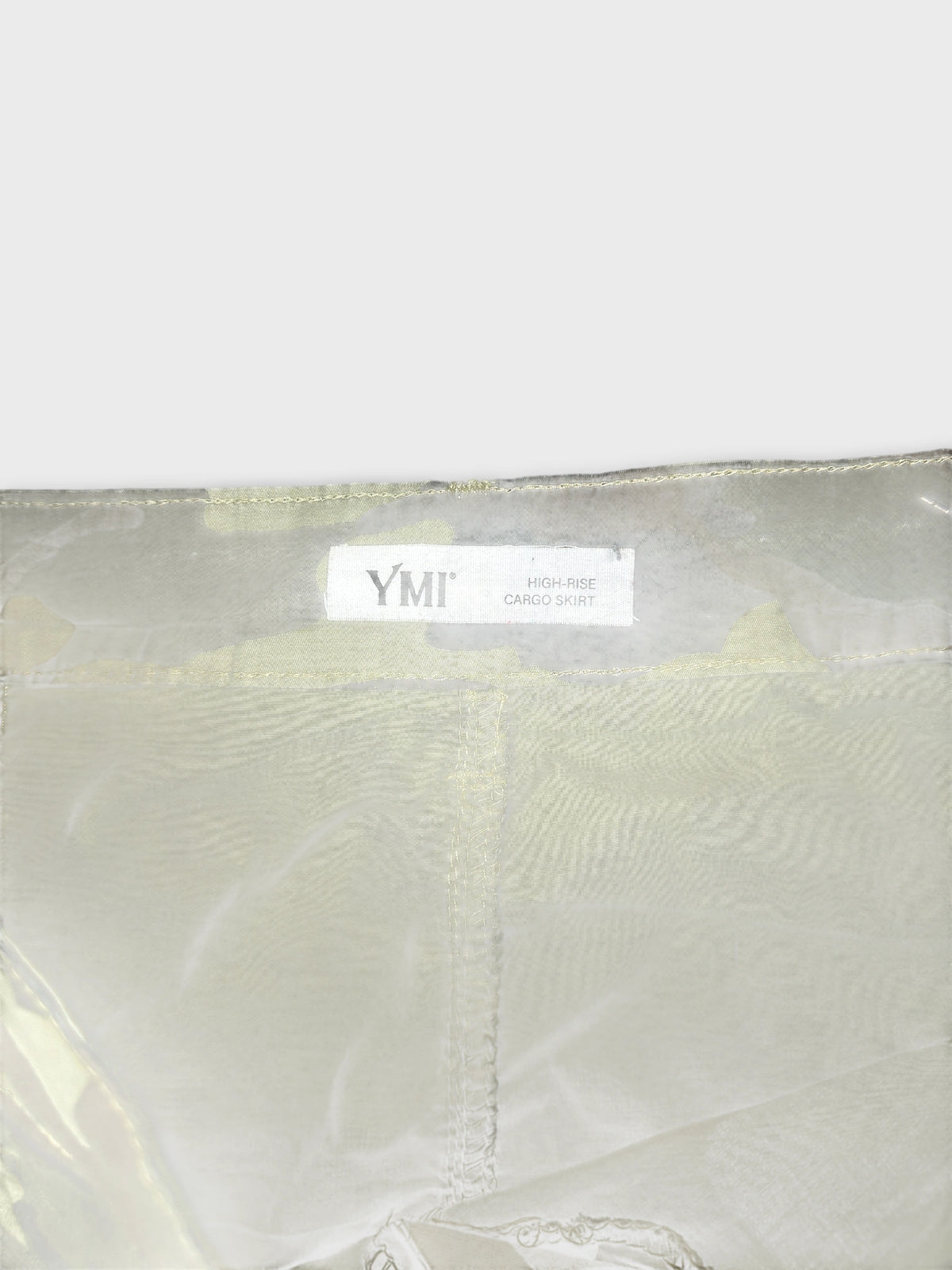 Detail view of a high-rise cargo skirt in light beige with visible stitching.