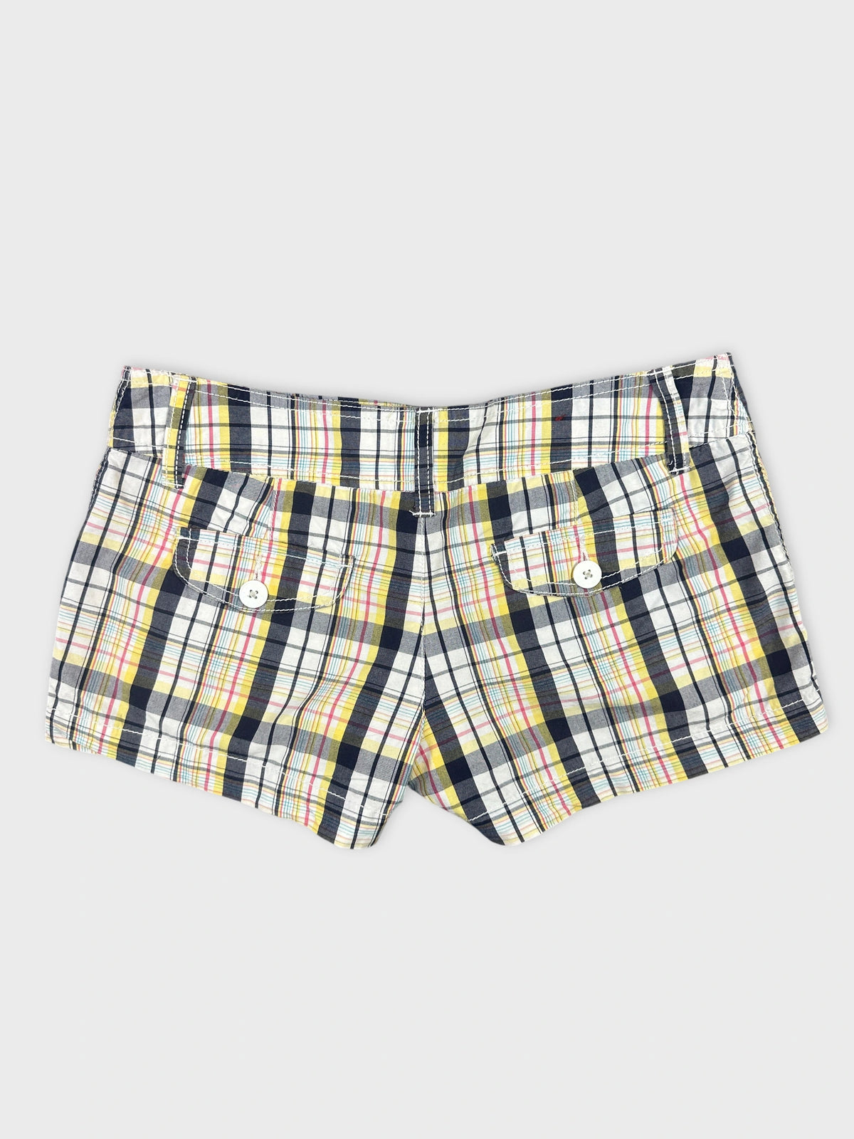 Back view of plaid women’s shorts featuring a mix of yellow and navy colors.