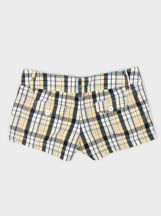Back view of plaid women’s shorts featuring a mix of yellow and navy colors.