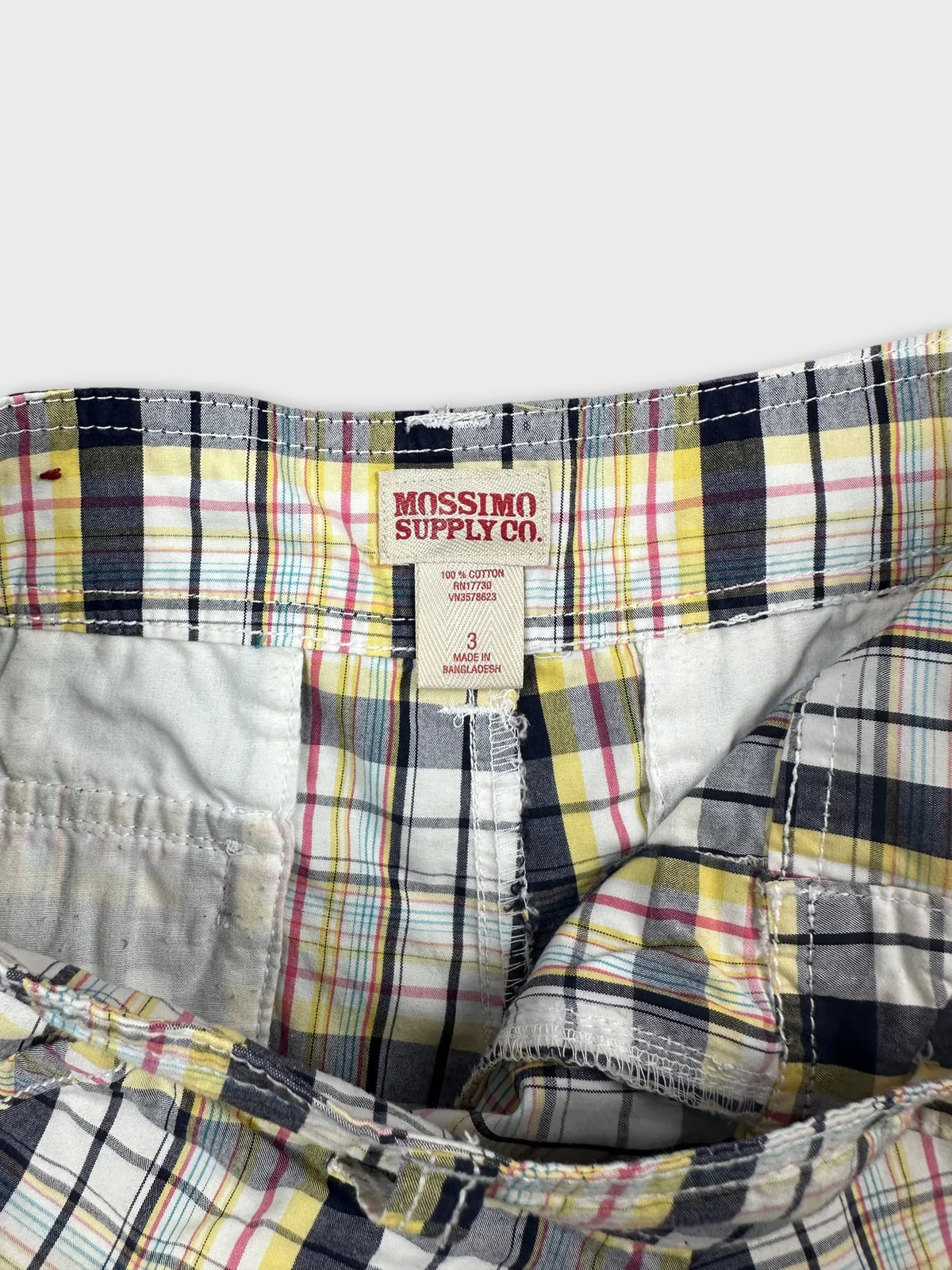 Detail view of women's shorts featuring a multicolored plaid pattern.