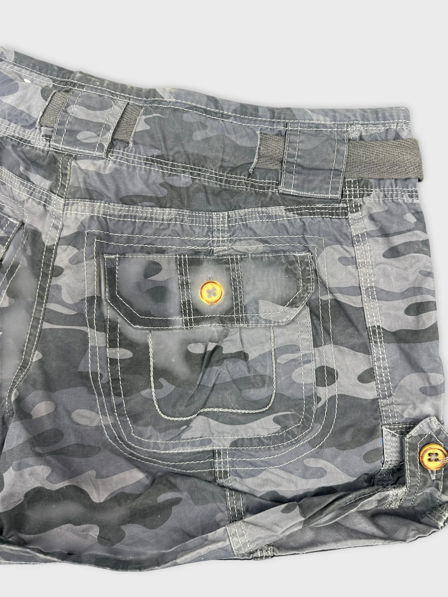 Detail view of gray camo women's shorts with a pocket and button detail.