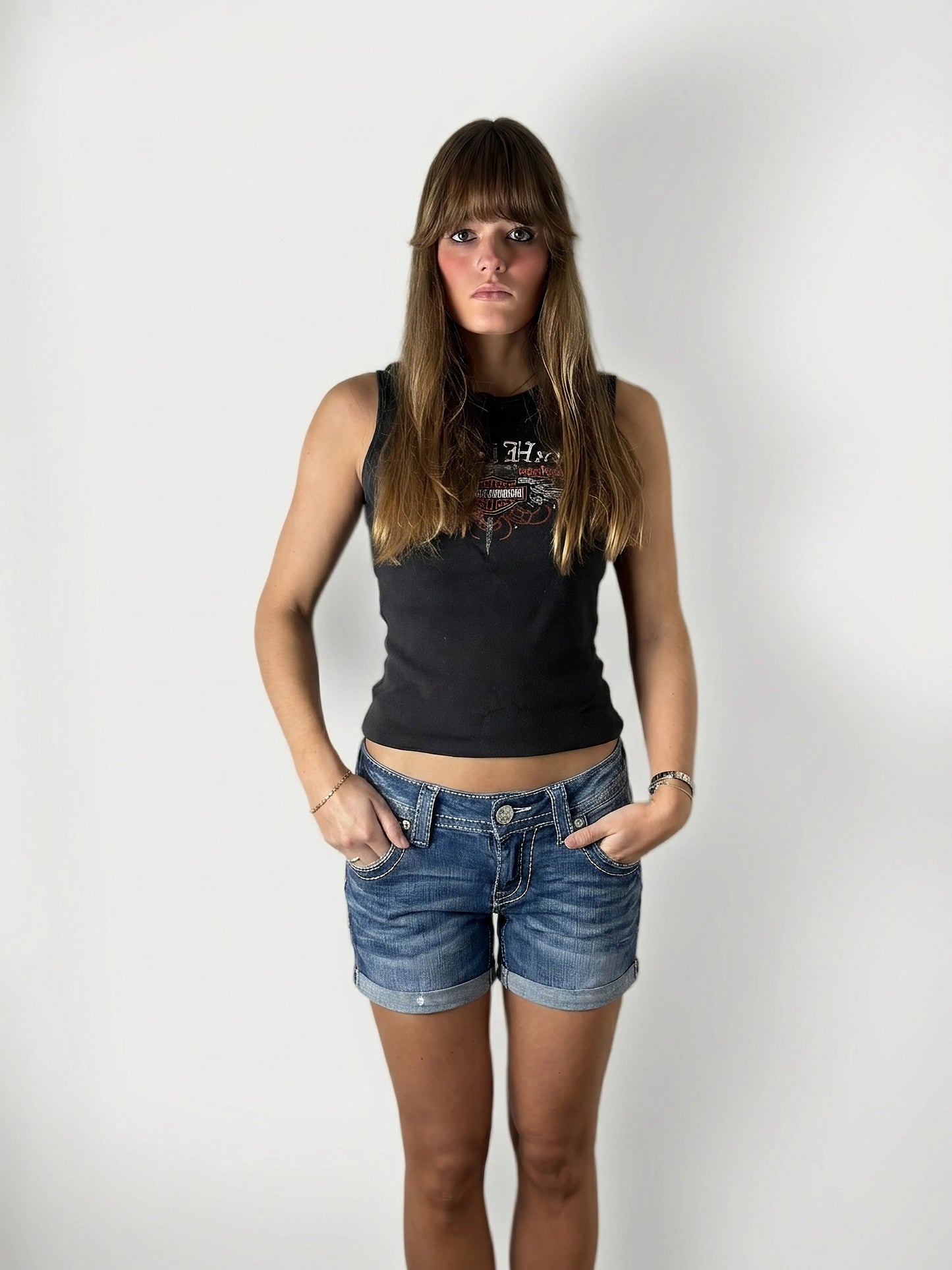 Front view of blue denim shorts featuring rolled hems and front pockets.