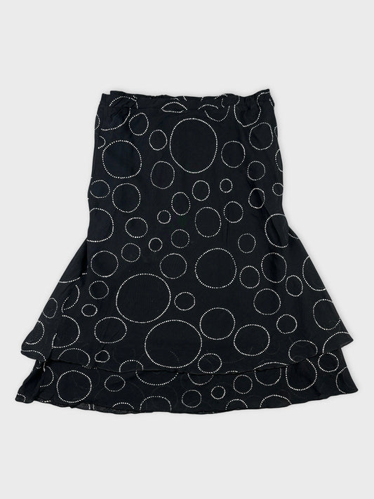 Back view of a black skirt with white polka dot pattern.