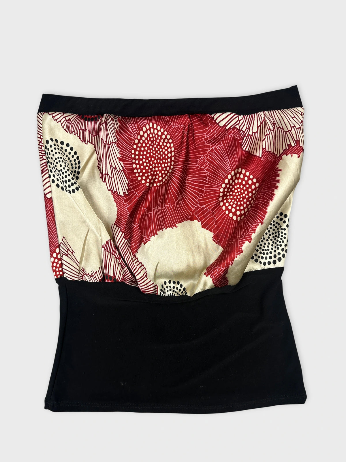 Back view of a women's skirt showcasing a red floral print with black trim.