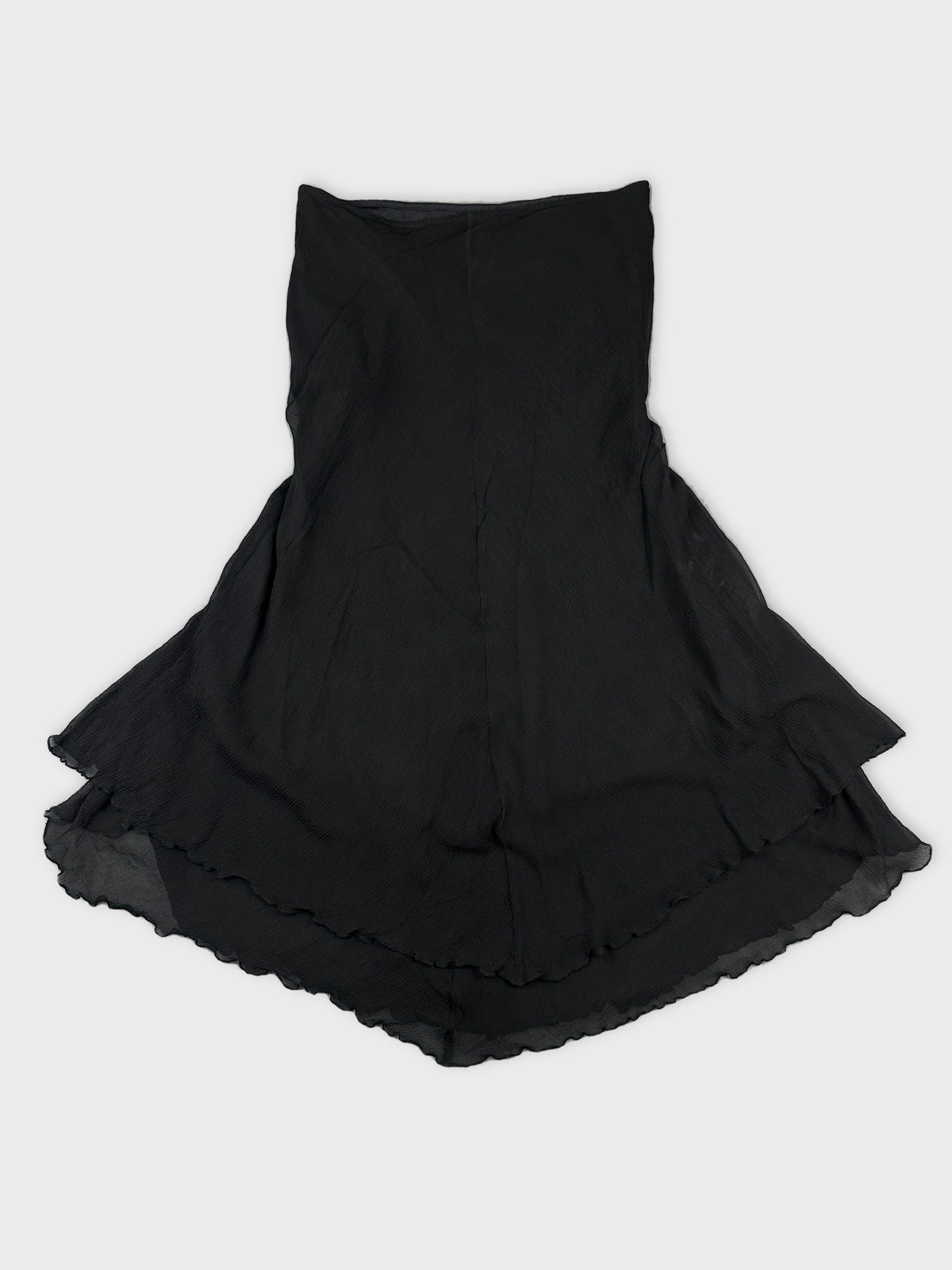 Back view of a black skirt with a ruffled hemline.