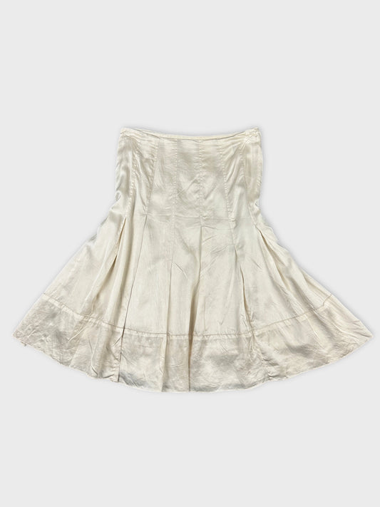 Back view of a white vintage skirt featuring pleats and a flared shape.