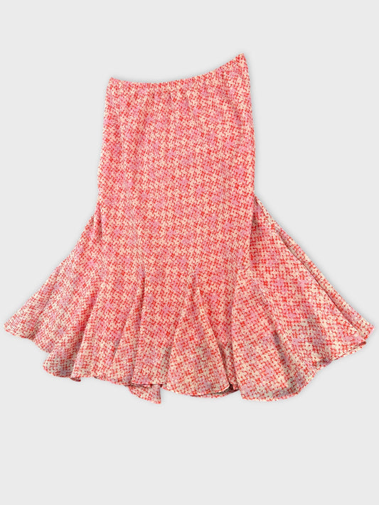 Back view of a pink patterned flared skirt with a ruffled hem.