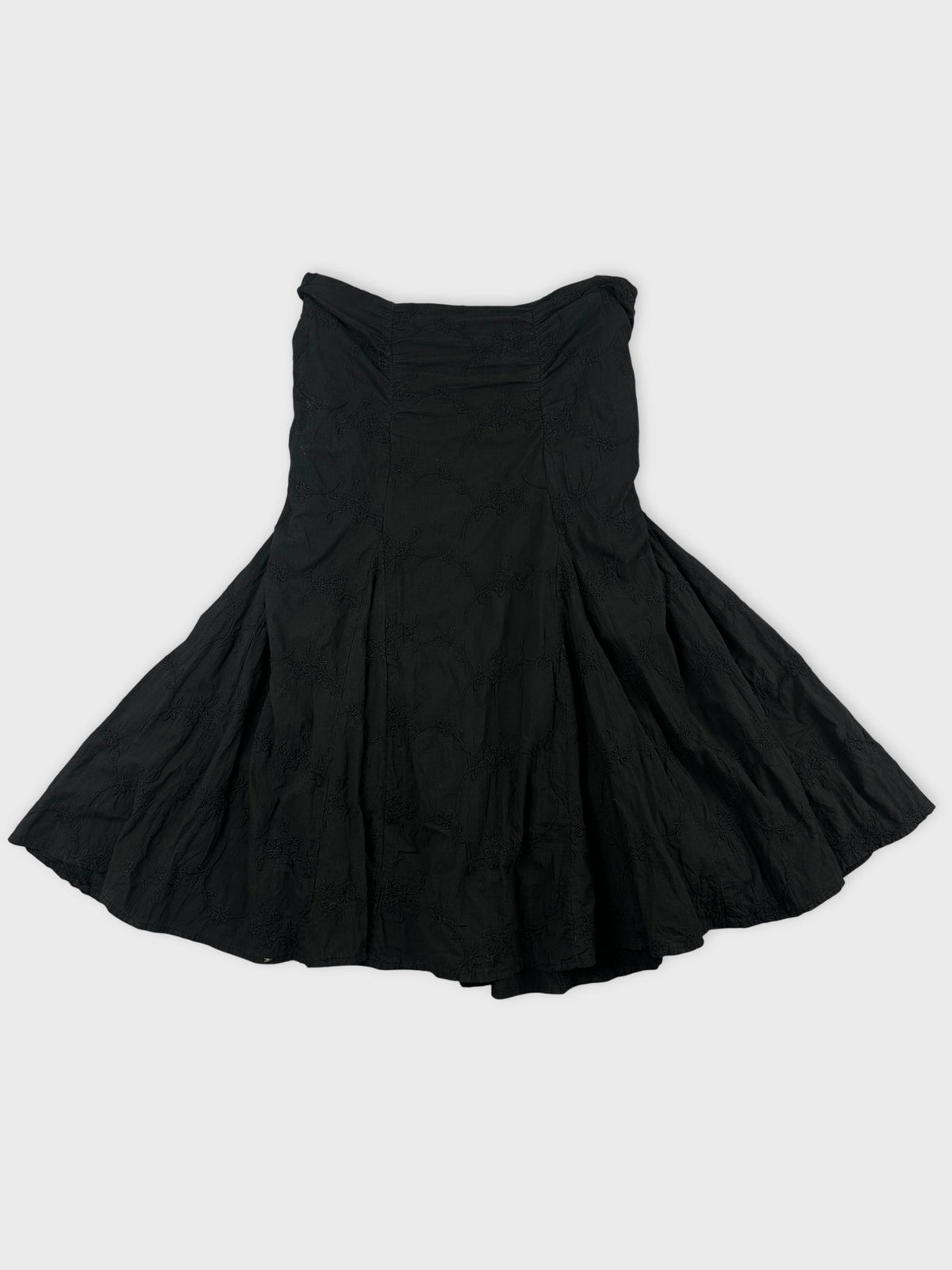 Back view of a black skirt featuring floral embroidery