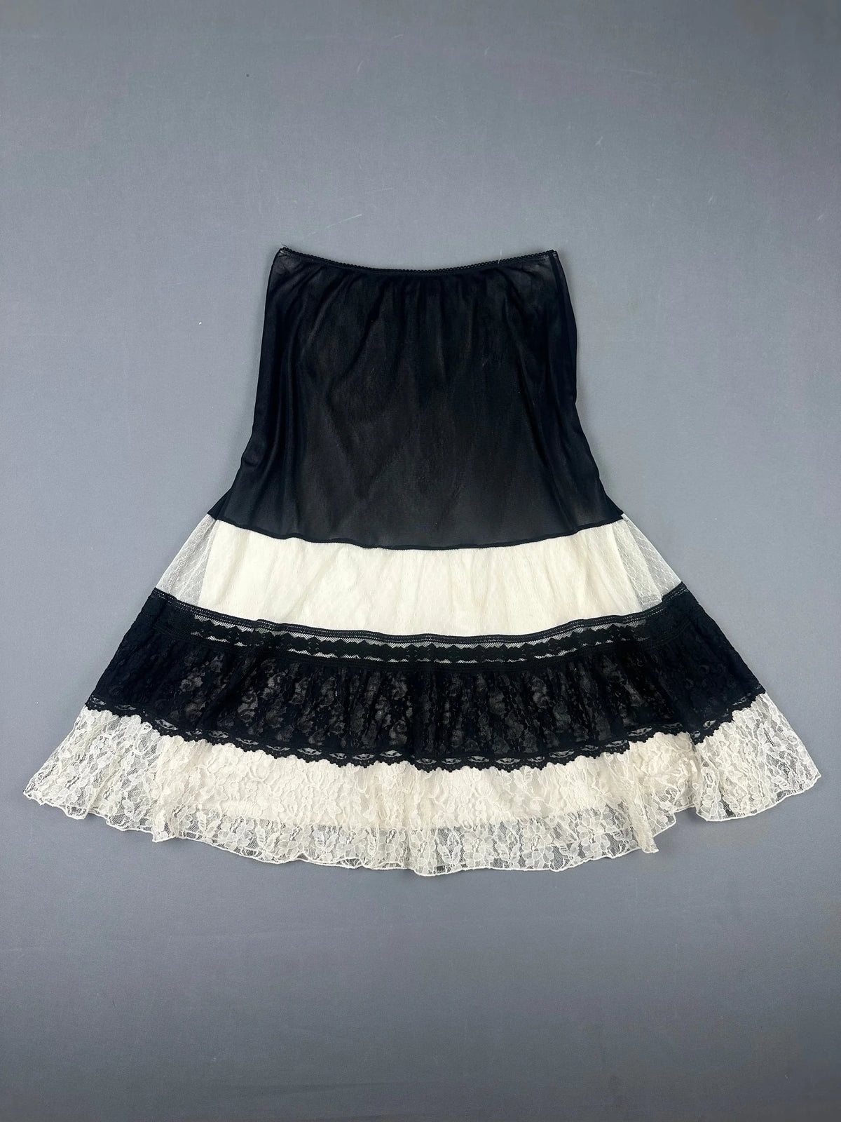 Back view of a black and white layered skirt with lace trim.