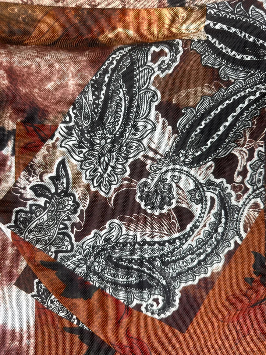 Detail view of a vintage skirt featuring a brown and black paisley pattern.
