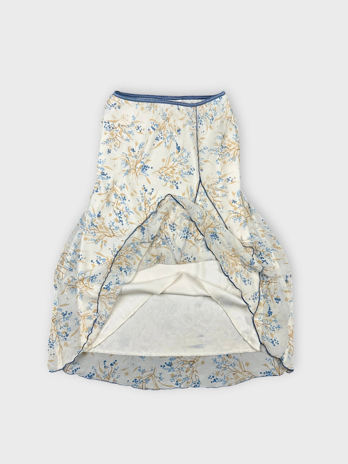 Detail view of a floral print skirt in cream and blue.