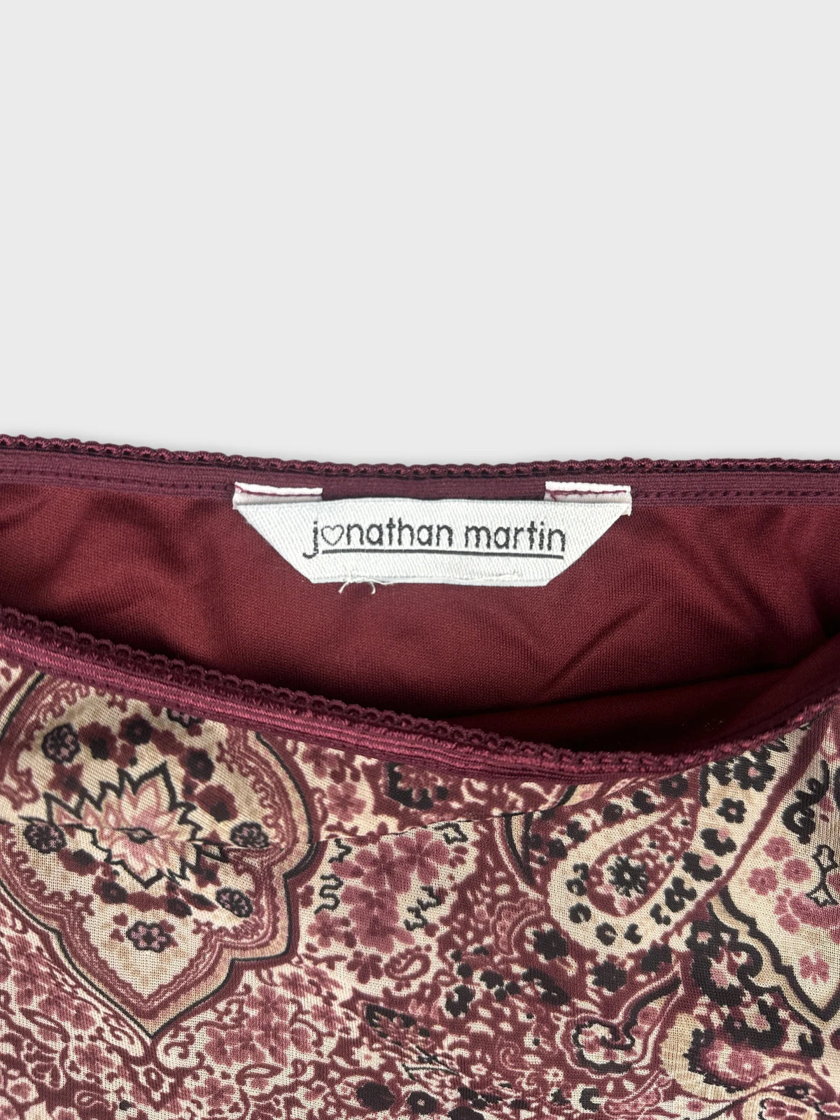 Detail view of women's skirt in burgundy with paisley pattern