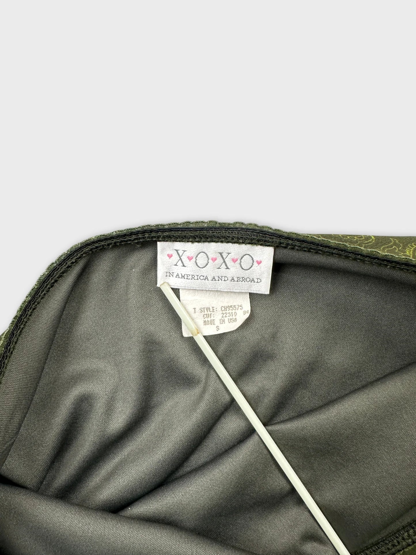detail view of a green skirt with a decorative trim inside.