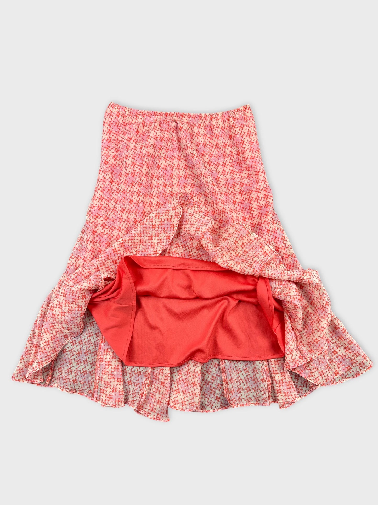 Detail view of a pink patterned vintage skirt with frilly hem.