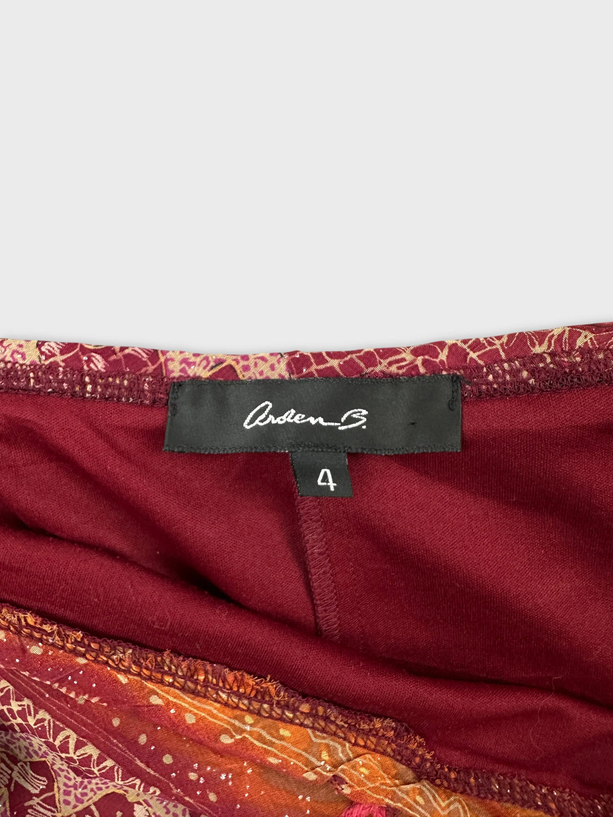 Detail view of a maroon skirt showing intricate floral patterns.