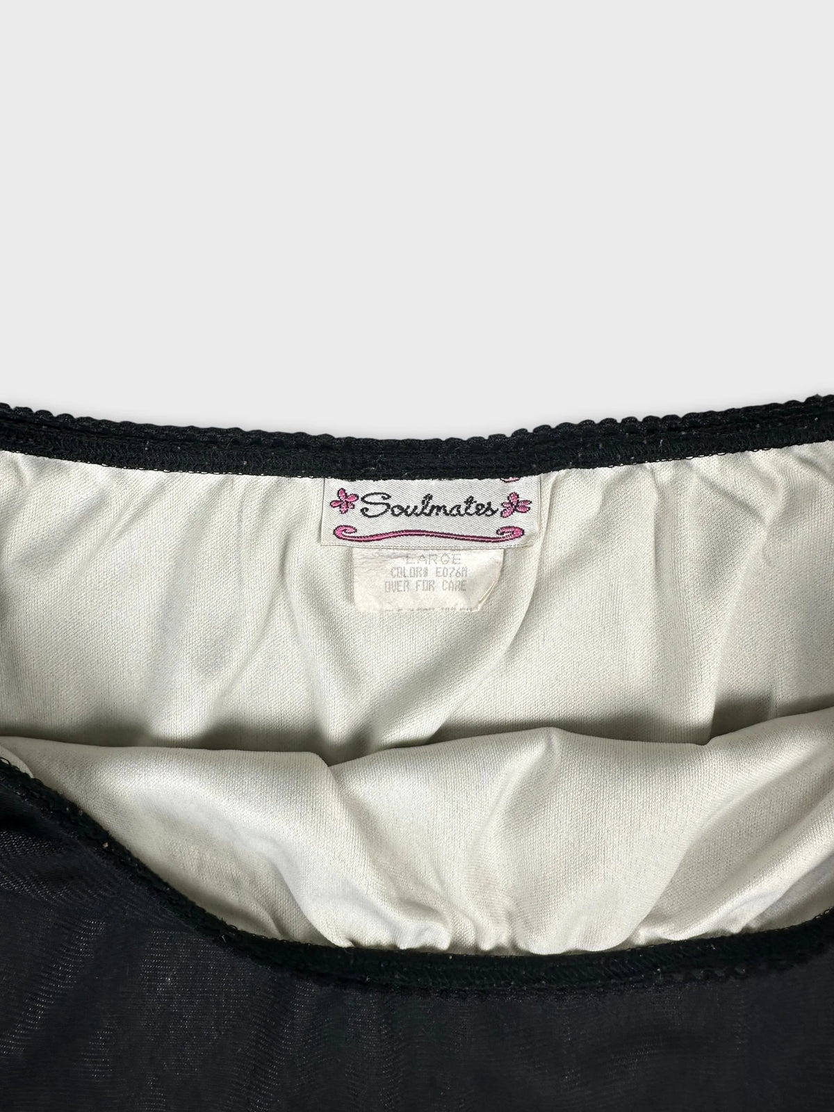 Detail view of a black women's skirt featuring a textured waistband.