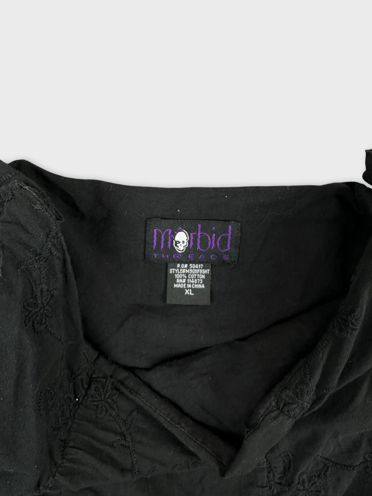 Detail view of a black flower-embroidered skirt's waistband.